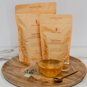 The Tonic Ginger Turmeric Teabag Pouches with a glass cup